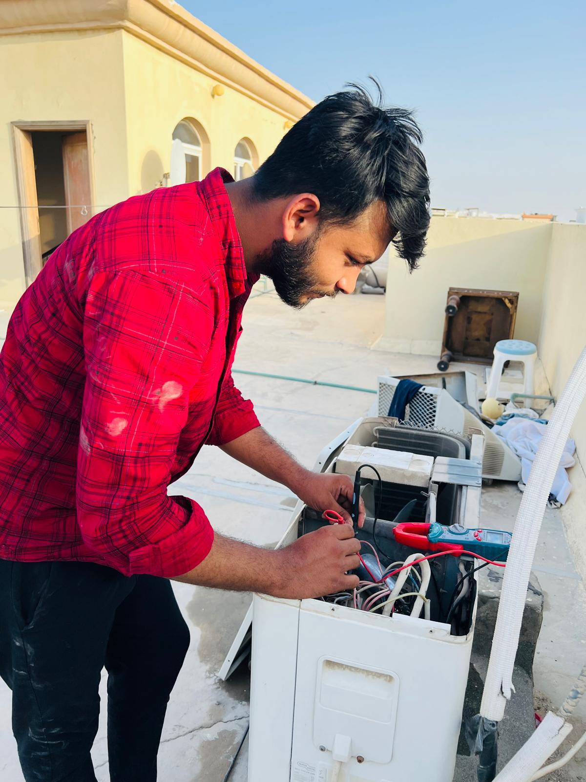 Technician checking AC parts during maintenance service